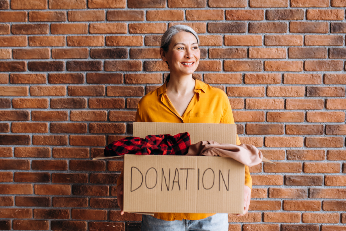 senior-woman-holding-cardboard-box-with-items-to-donate